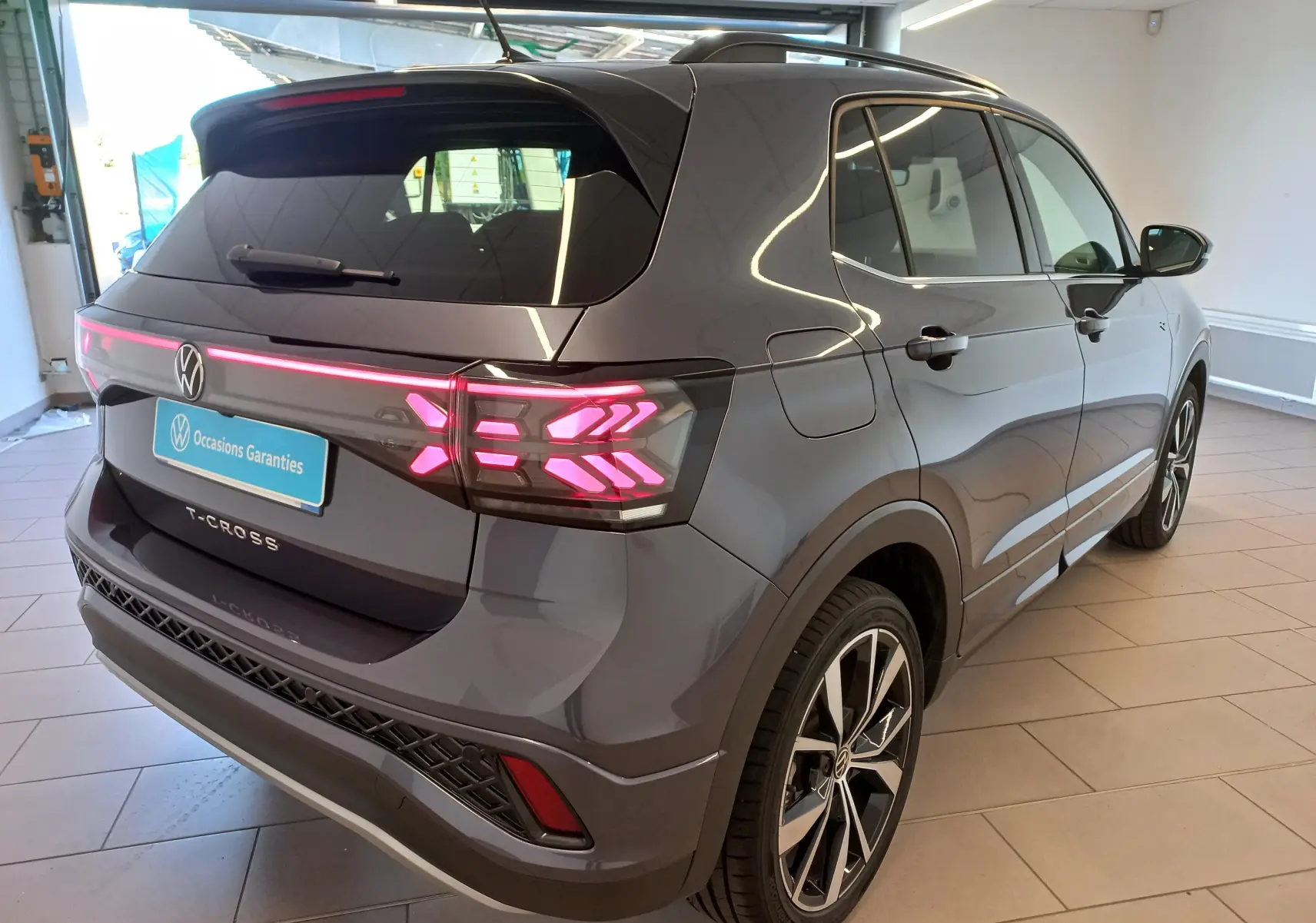 Vue 3/4 arrière droite du Volkswagen T-Cross gris cendré avec feux arrière LED et jantes alliage 18 pouces Misano.