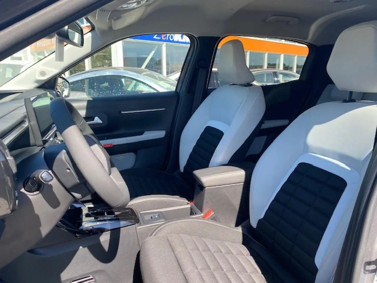 Vue intérieure avant droite du Citroën C3 Aircross 2026, sièges bicolores noir et blanc avec console centrale noire.