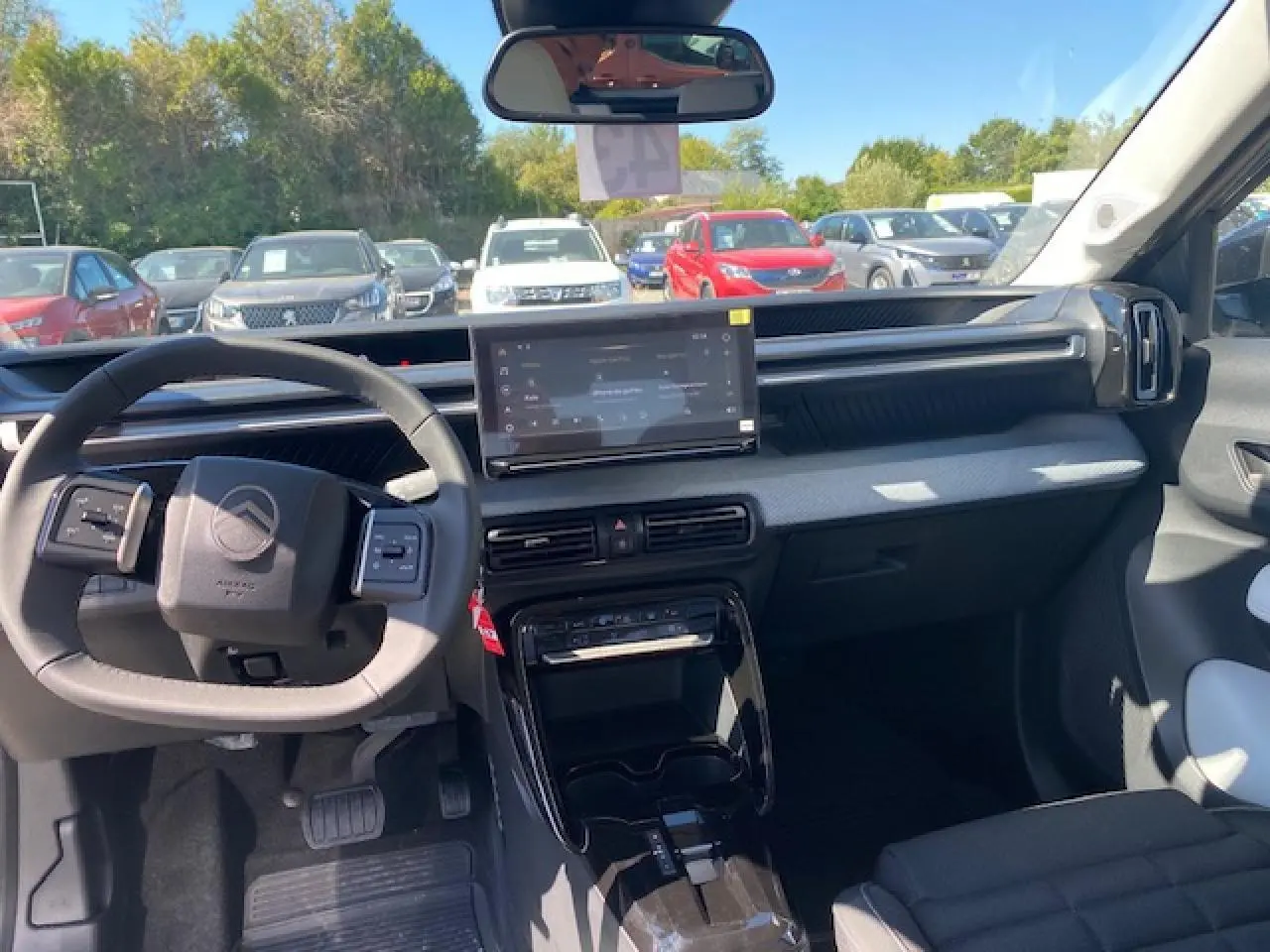 Vue intérieure du tableau de bord et volant du Citroën C3 Aircross 2026 avec écran tactile central et finitions gris clair.