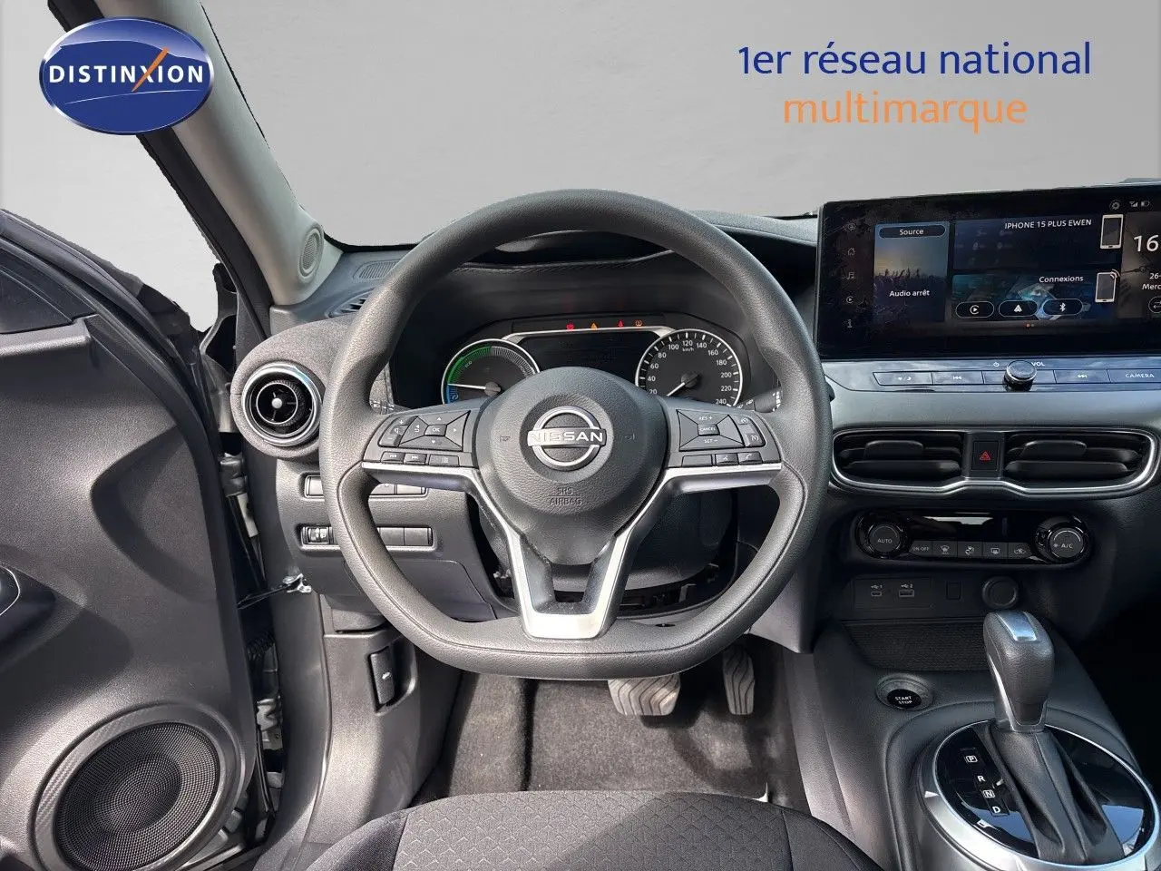 Vue intérieure centrée sur le volant Nissan Juke 2024, tableau de bord moderne avec écran tactile et levier de boîte auto.