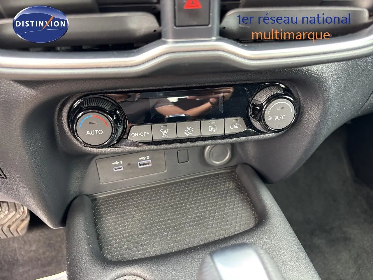 Vue rapprochée de la console arrière entre les sièges noirs en tissu du Nissan Juke gris Squale Metal 2024.