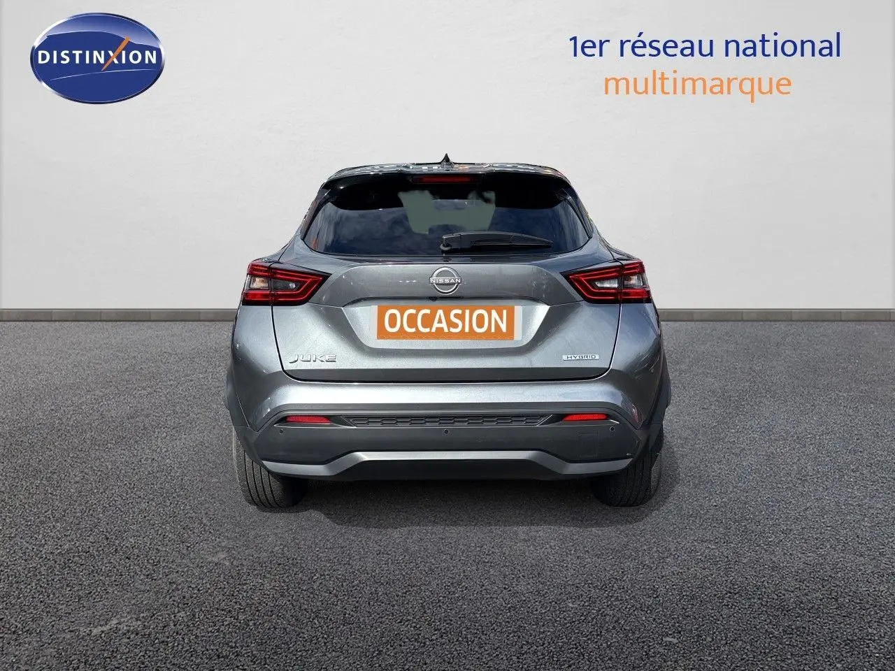Vue arrière d'un Nissan Juke Hybrid 143ch Business Edition gris squale métal, avec feux LED et plaque "OCCASION".