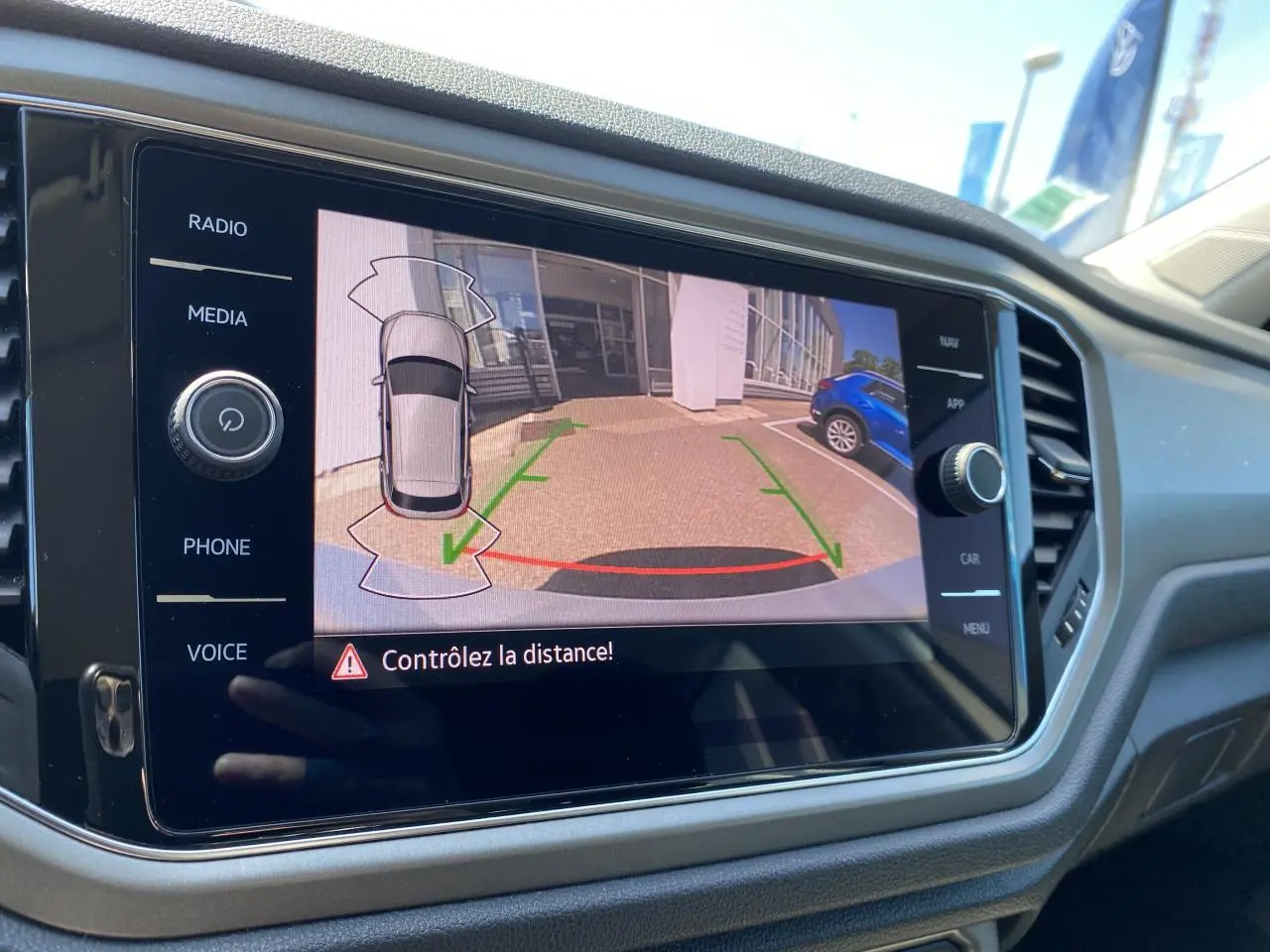 Écran de caméra de recul du Volkswagen T-Roc montrant l'arrière avec guidage de trajectoire en stationnement.