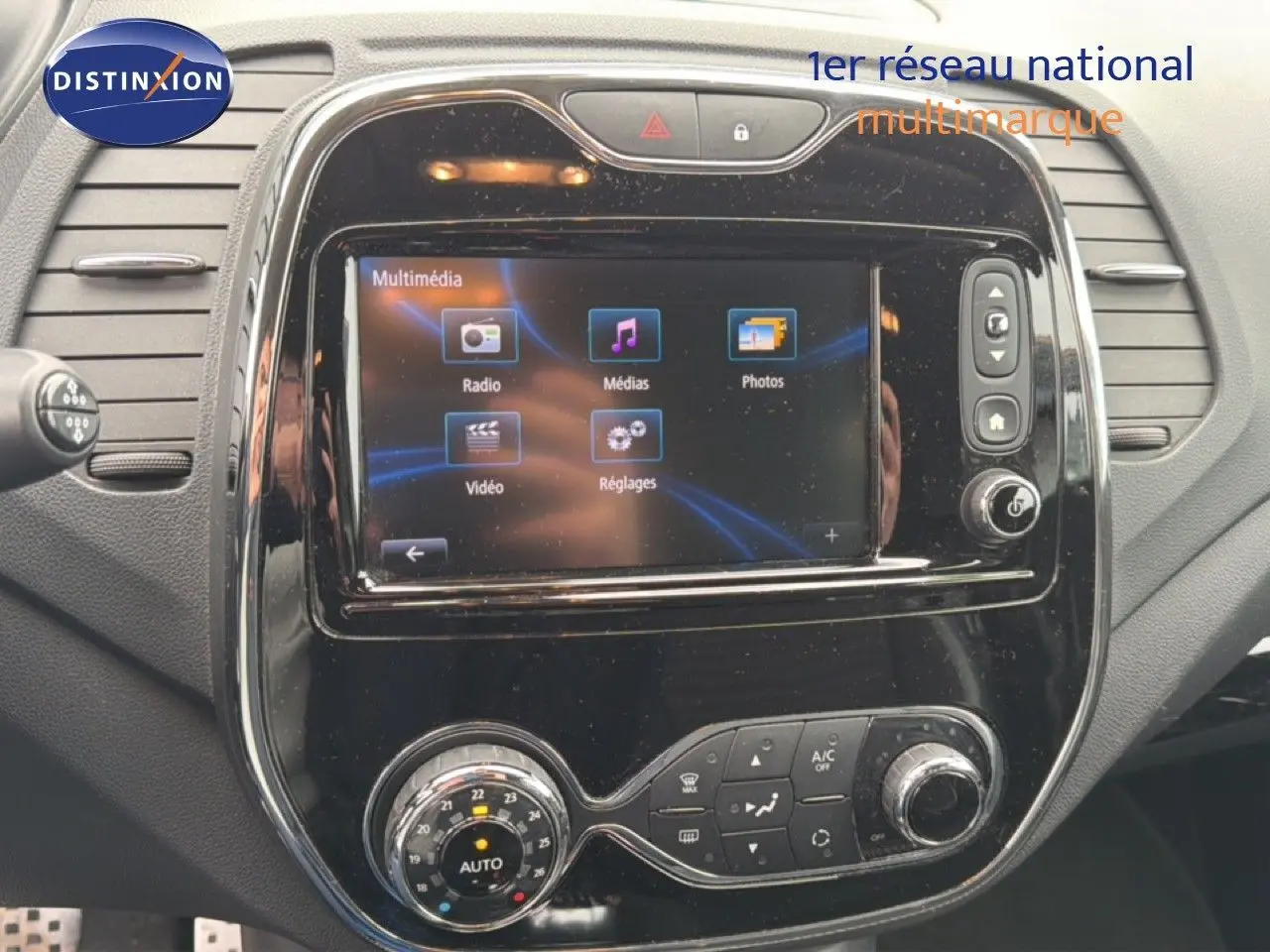 Vue rapprochée de la console centrale noire brillante du Renault Captur 2016 avec écran tactile multimédia allumé.