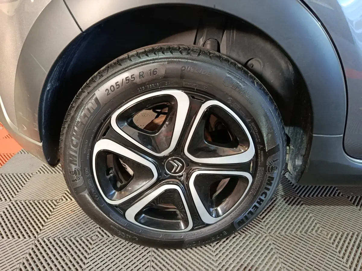 Gros plan sur la roue avant droite gris foncé d'une Citroën C3 2024 avec jante alliage noire et argentée.