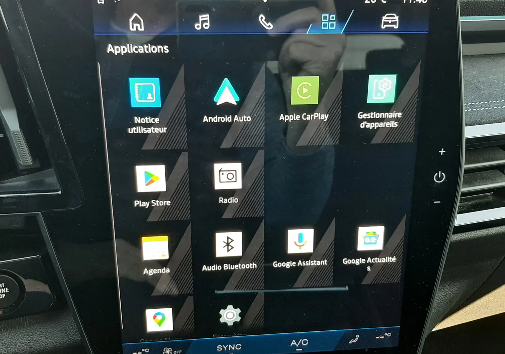 Écran tactile central de la Renault Austral 2025, affichant les applications connectées avec tableau de bord noir.