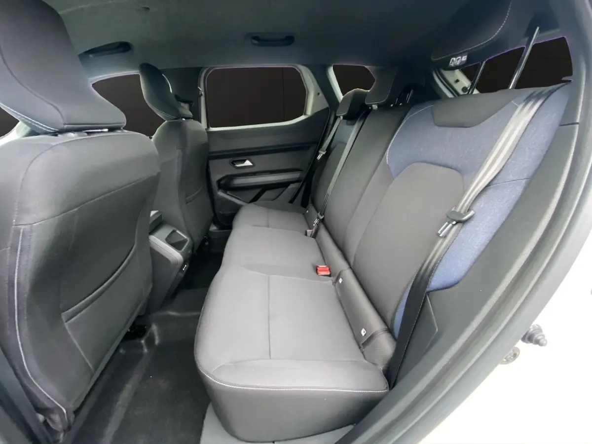 Vue intérieure côté droit sur la banquette arrière noire et grise du Dacia Duster beige, version Journey Hybrid 140.