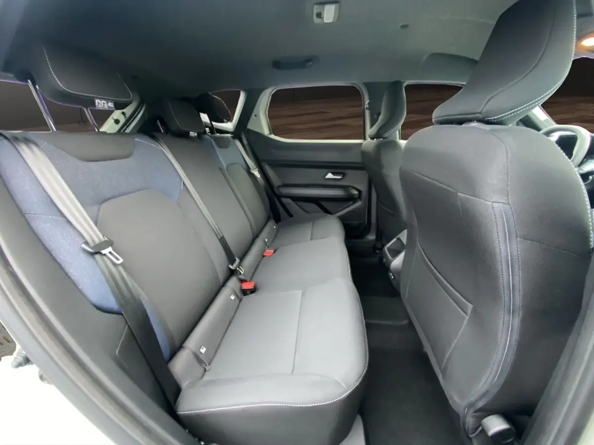 Vue intérieure montrant la banquette arrière noire et grise du Dacia Duster 2025, côté gauche, avec appuie-têtes et ceintures.