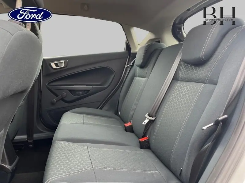 Vue intérieure de la banquette arrière en tissu gris de la Ford Fiesta 2012, côté droit avec ceintures visibles.