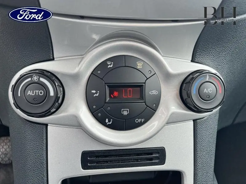Gros plan sur les commandes de climatisation automatique gris argenté de la Ford Fiesta Titanium 2012.