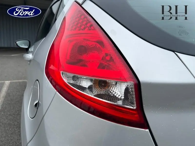 Gros plan sur le feu arrière droit d'une Ford Fiesta gris lunaire, soulignant la carrosserie et la trappe à carburant.