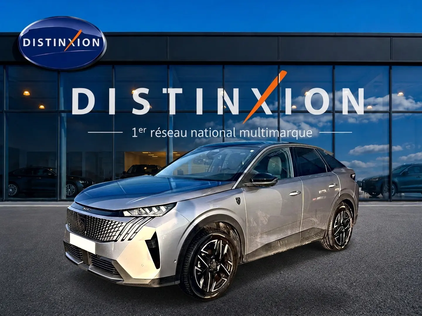 Peugeot 3008 gris en 3/4 avant droit, avec calandre distinctive et jantes alliage noires devant showroom Distinxion.