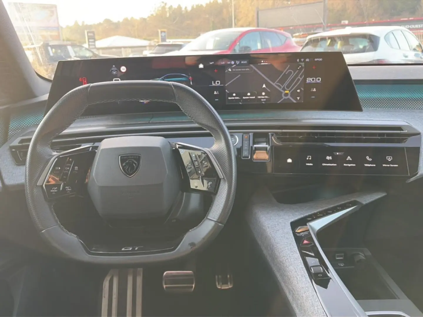 Vue intérieure centrée sur le volant cuir multifonction et l'écran tactile large du tableau de bord du Peugeot 3008 gris.