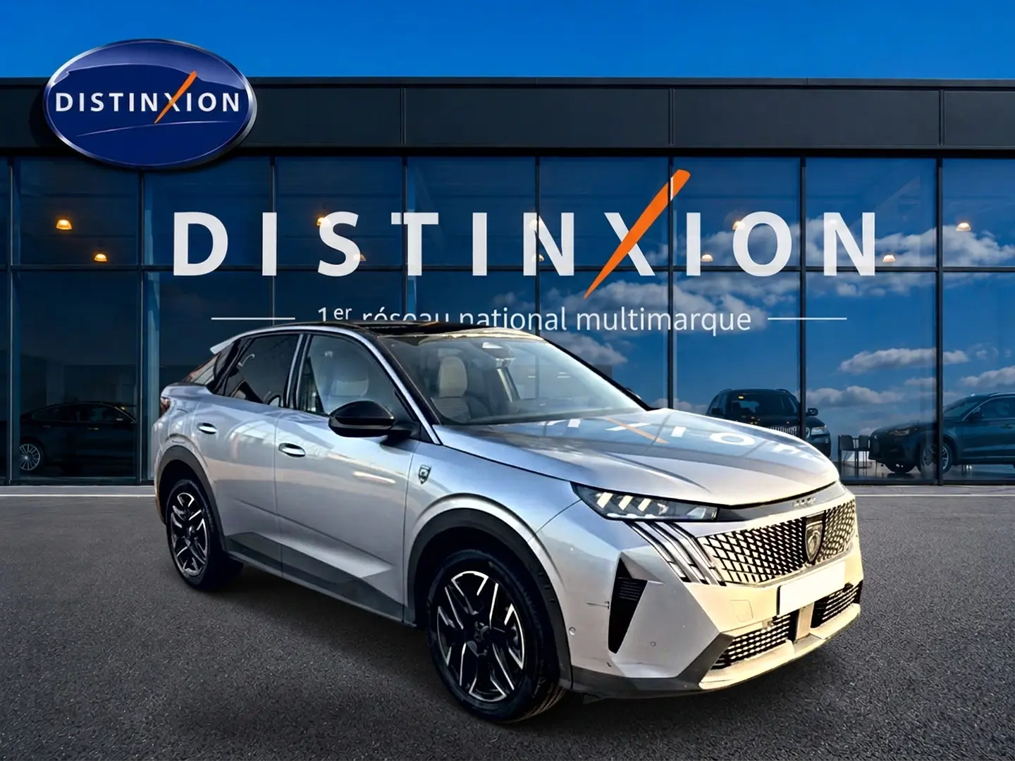 Peugeot 3008 gris en 3/4 avant droit, avec calandre distinctive et jantes alliage noires devant showroom Distinxion.