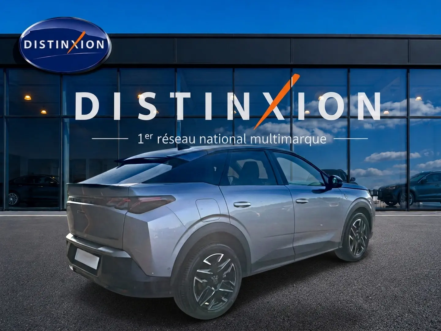 Peugeot 3008 gris en 3/4 arrière droit, avec jantes alu noires et toit noir devant une vitrine Distinxion.