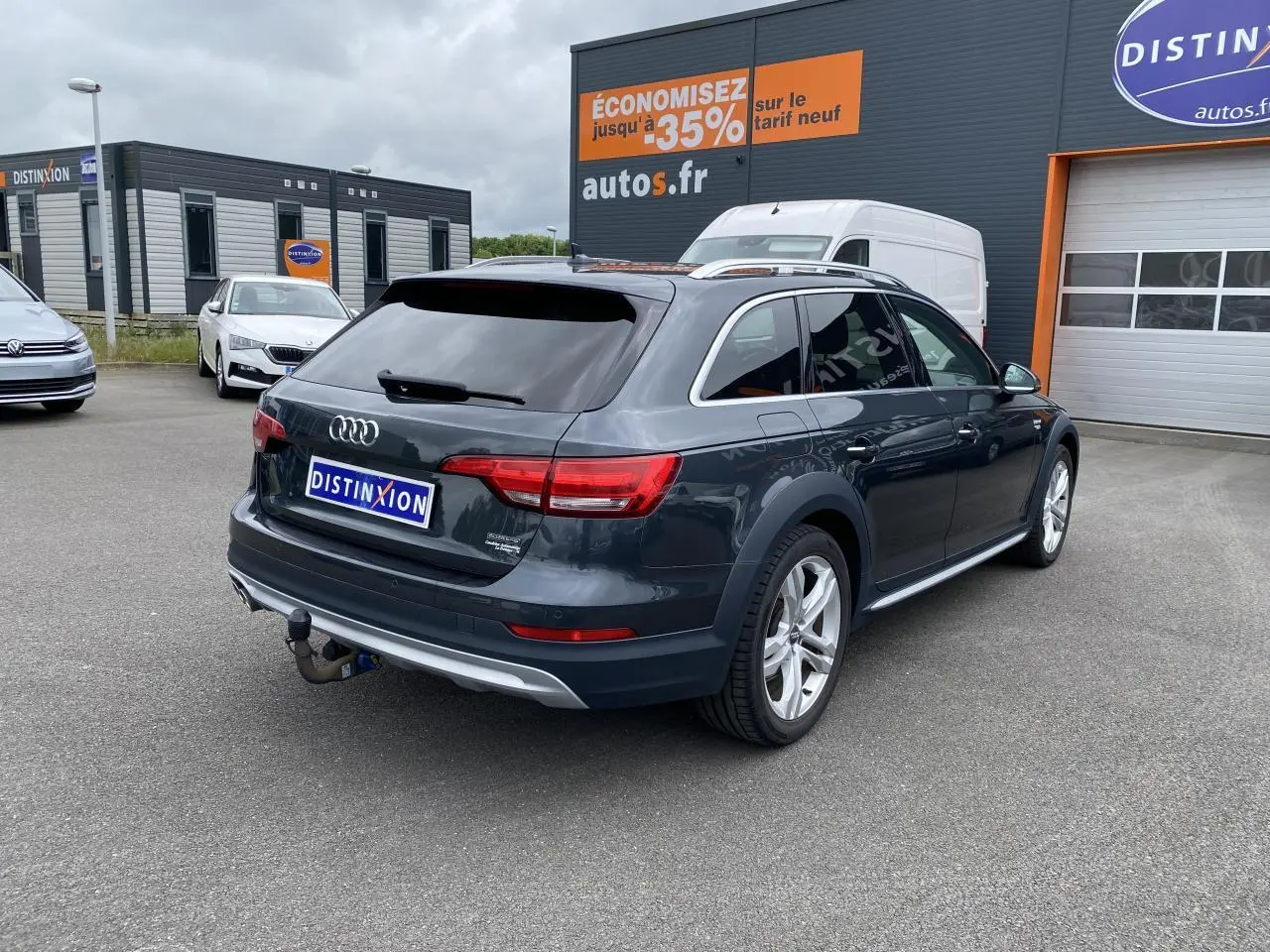 Audi A4 Allroad Quattro gris Manhattan vue 3/4 arrière droit avec crochet d'attelage et vitres surteintées.