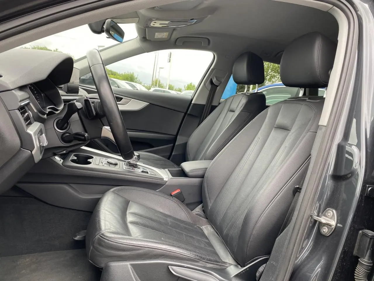 Intérieur avant droit de l'Audi A4 Allroad Quattro 2016 avec sièges cuir noirs et console centrale moderne.