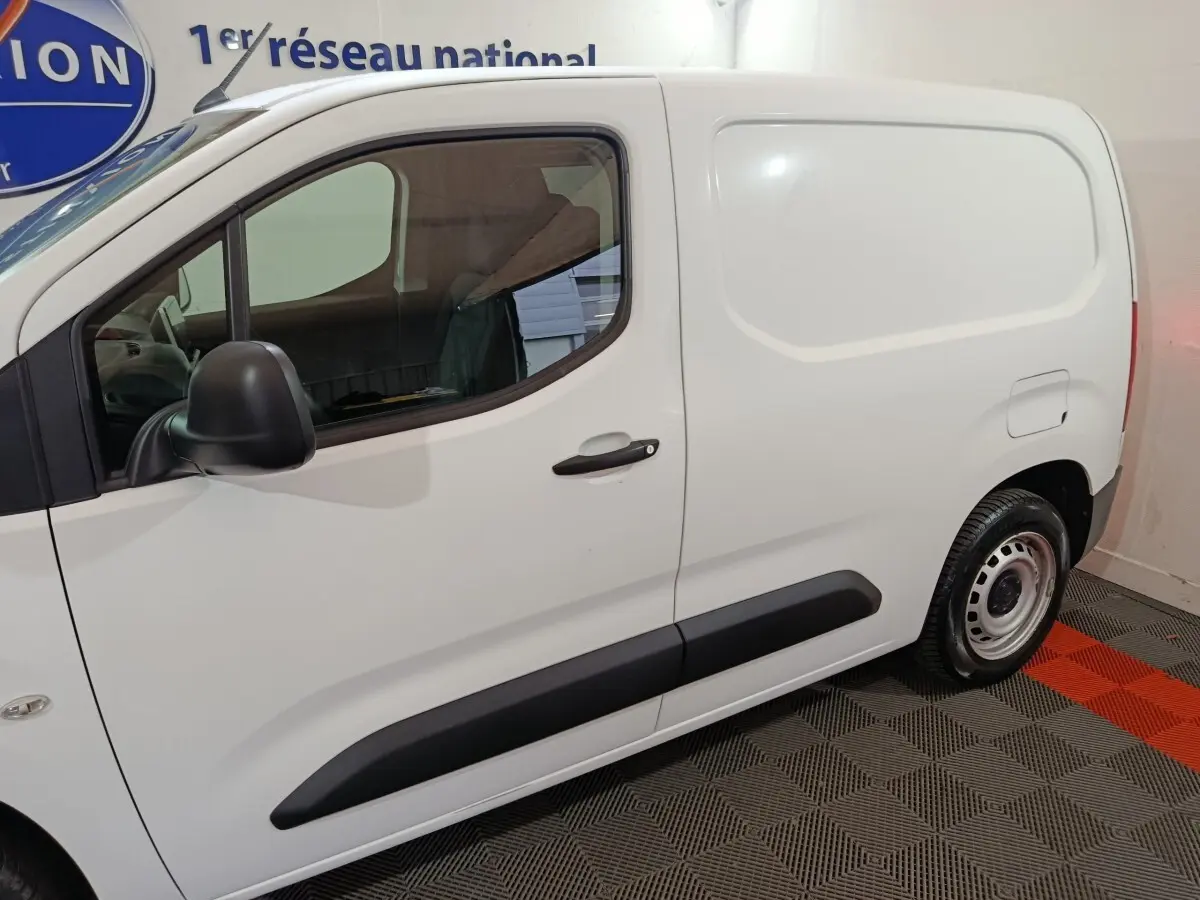 Vue latérale gauche d’un utilitaire Citroën Berlingo blanc avec porte latérale pleine et jante acier.