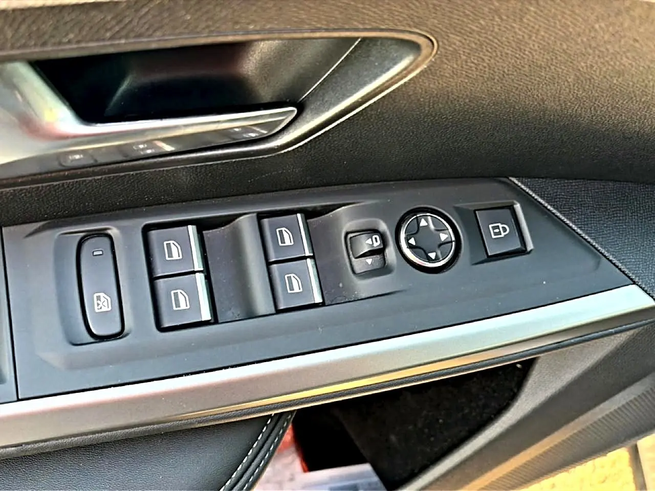 Gros plan sur les commandes de vitres et rétroviseurs côté gauche de la Peugeot 3008 gris 2025.