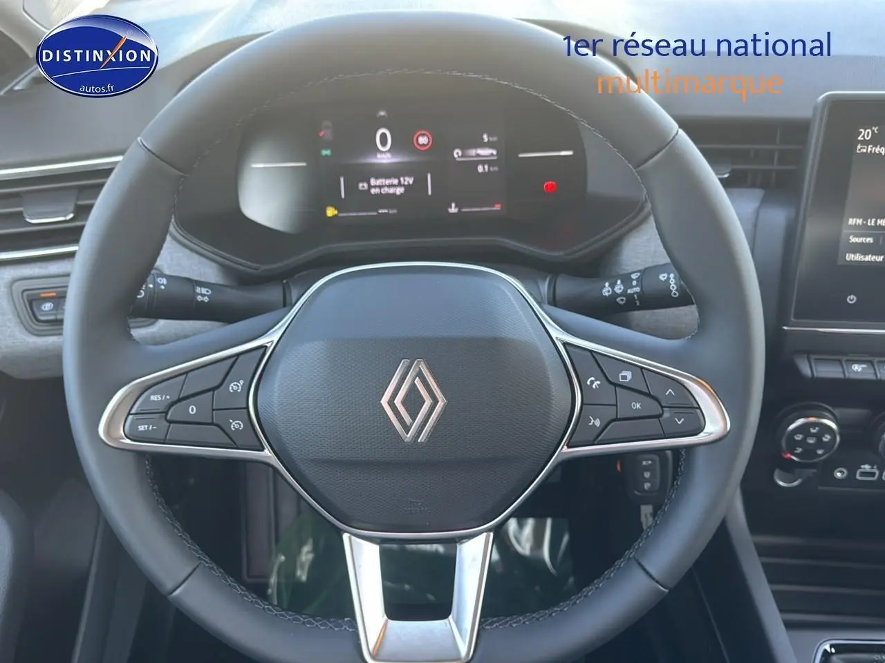 Vue rapprochée du volant multifonction noir de la Renault Clio V 1.5 Blue dCi 100 Evolution avec tableau de bord numérique.