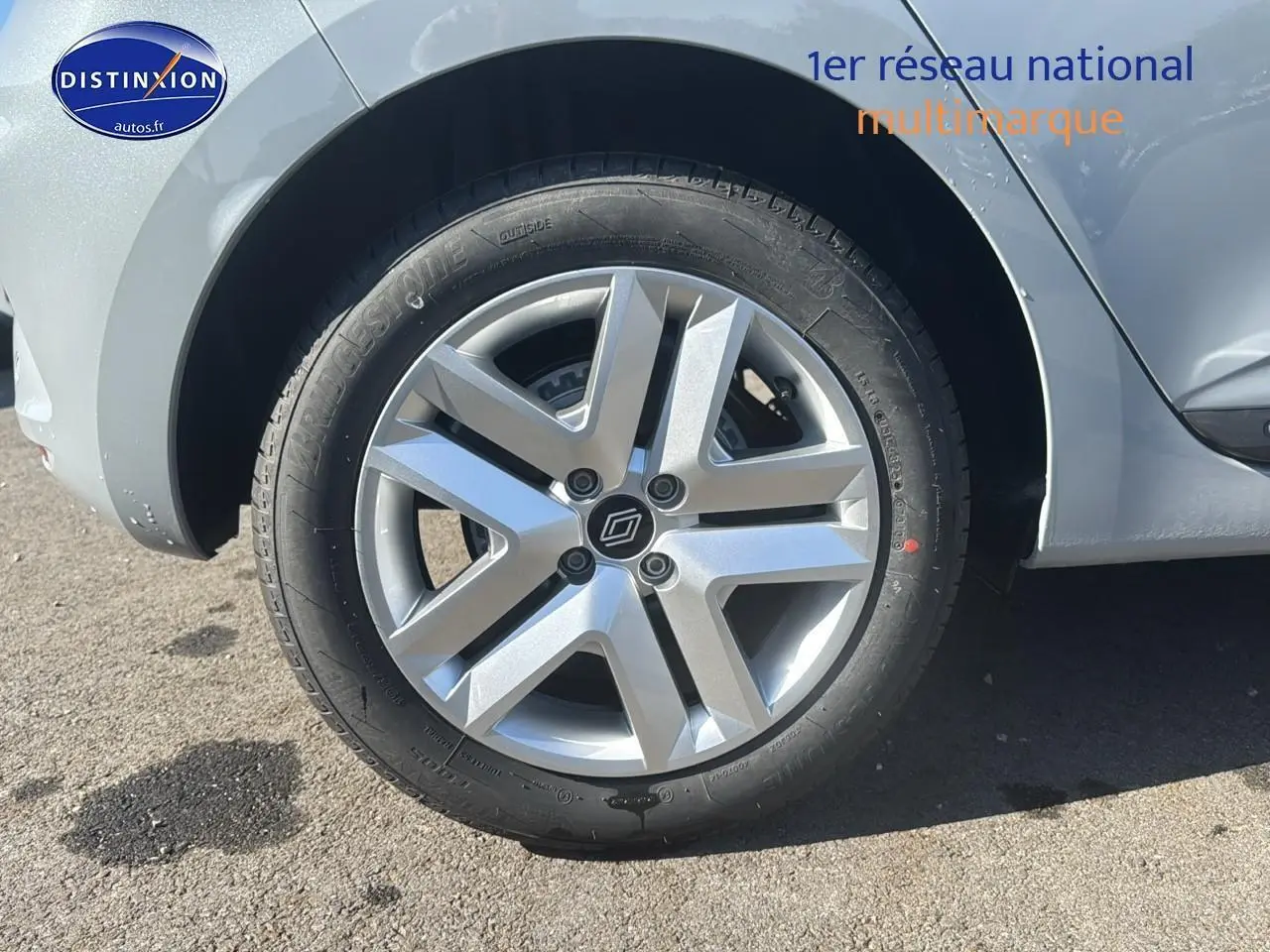 Gros plan sur la roue avant droite et jante argentée d'une Renault Clio V gris rafale.