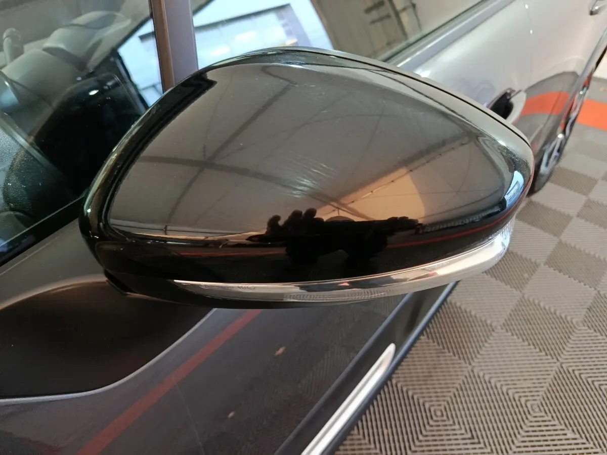Gros plan sur le rétroviseur droit noir brillant de la Citroën C3 gris foncé, avec clignotant intégré visible.