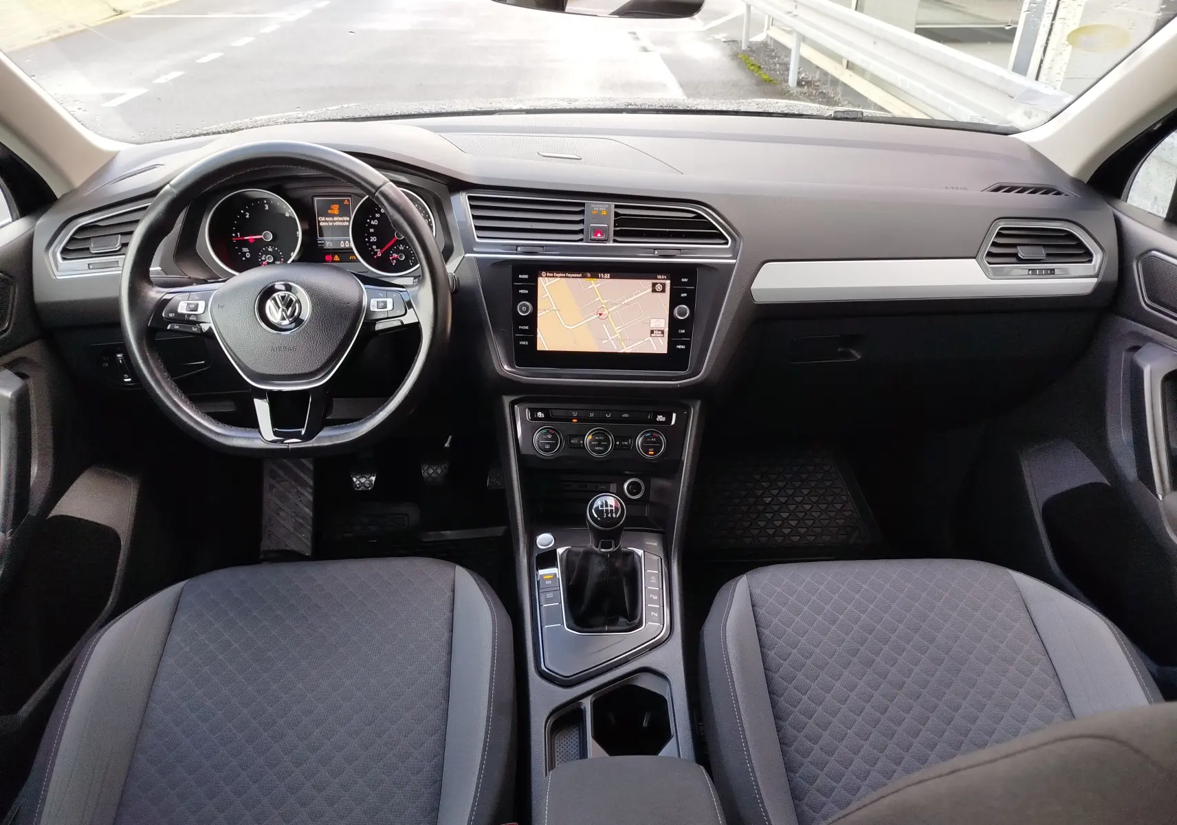 Vue intérieure frontale du Volkswagen Tiguan 2.0 TDI 2019, tableau de bord noir avec écran tactile et boîte manuelle.