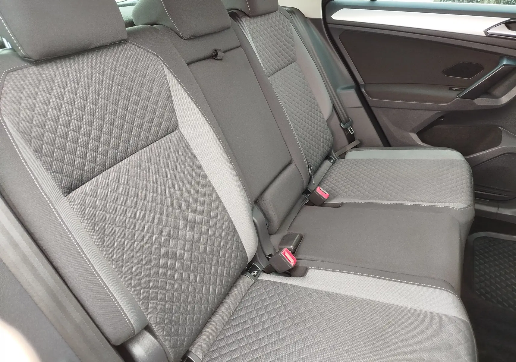 Vue latérale droite de la banquette arrière gris foncé avec surpiqûres en losanges du Volkswagen Tiguan 2019.