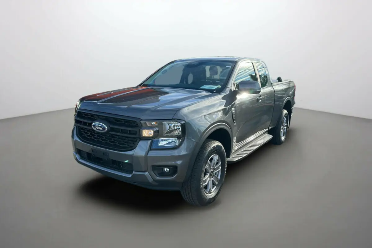 Ford Ranger gris carbone en 3/4 avant droit avec marchepieds et benne ouverte visible.