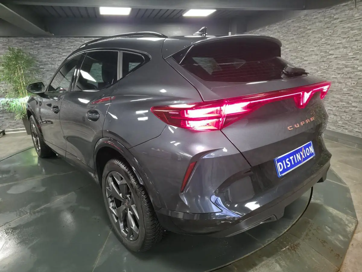 Vue 3/4 arrière droite du CUPRA Formentor gris avec signature lumineuse Tri-LED et jantes alliage 18 pouces.