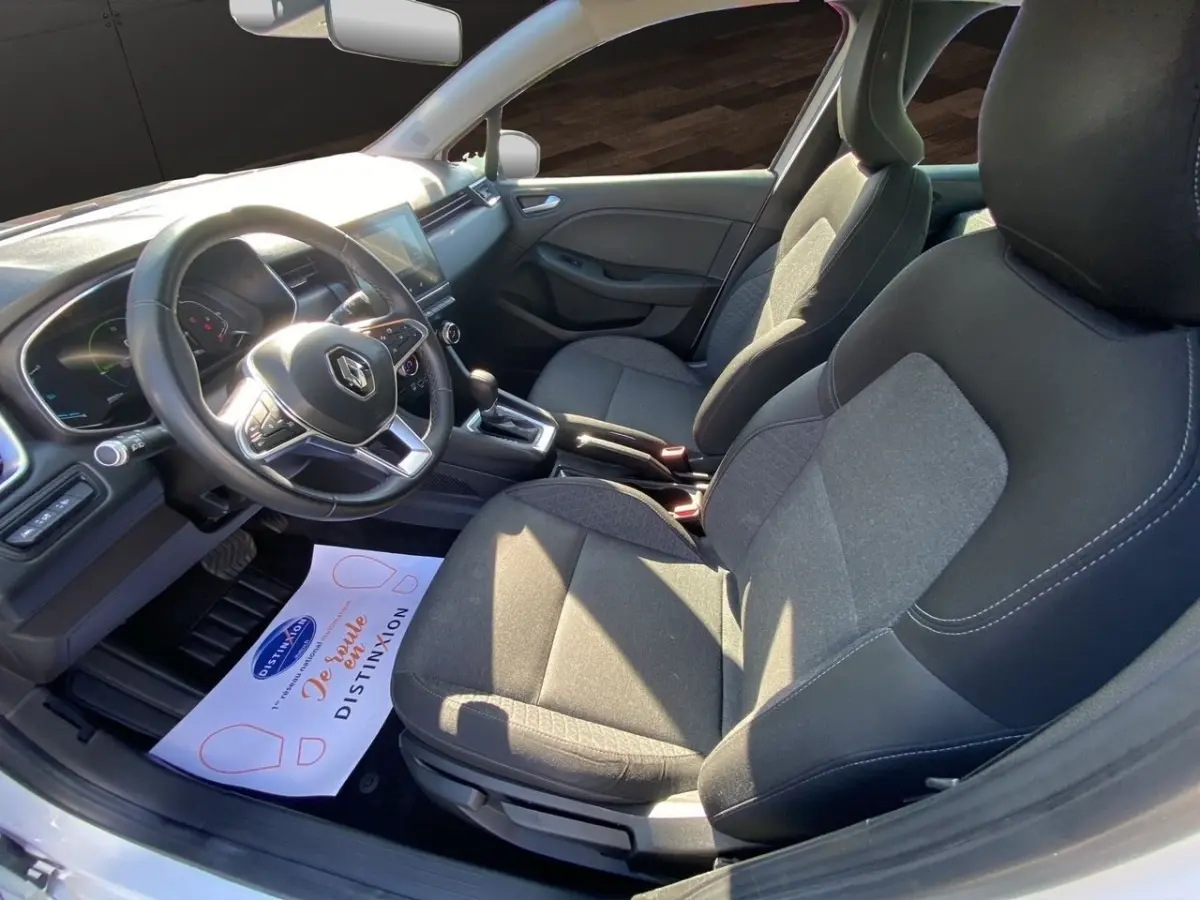 Vue intérieure côté conducteur de la Renault Clio Business E-TECH 140 2021, sièges gris et volant multifonctions cuir synthétique.