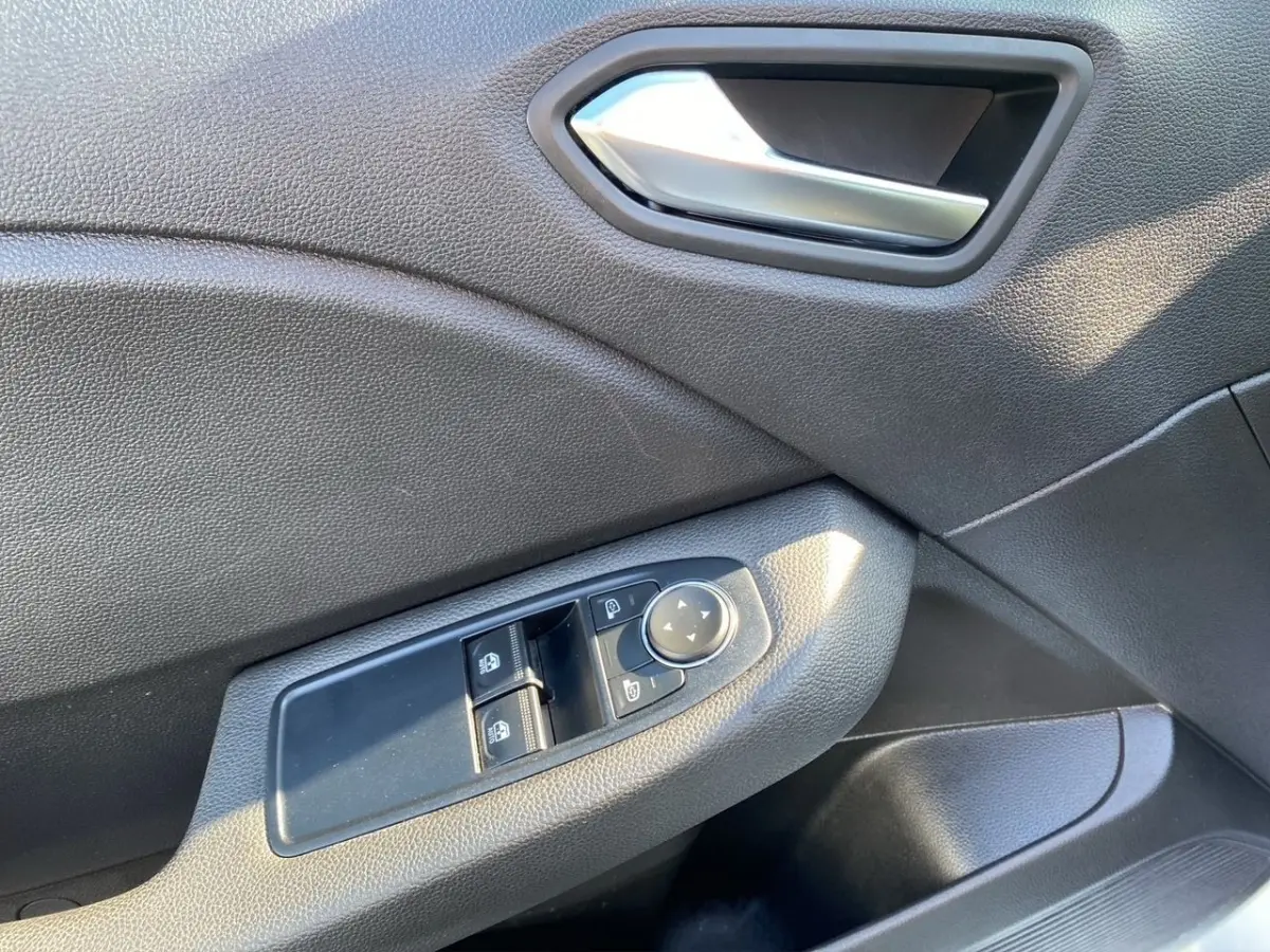 Détail de la commande des vitres et rétroviseurs sur la porte côté conducteur d'une Renault Clio blanche, 2021.