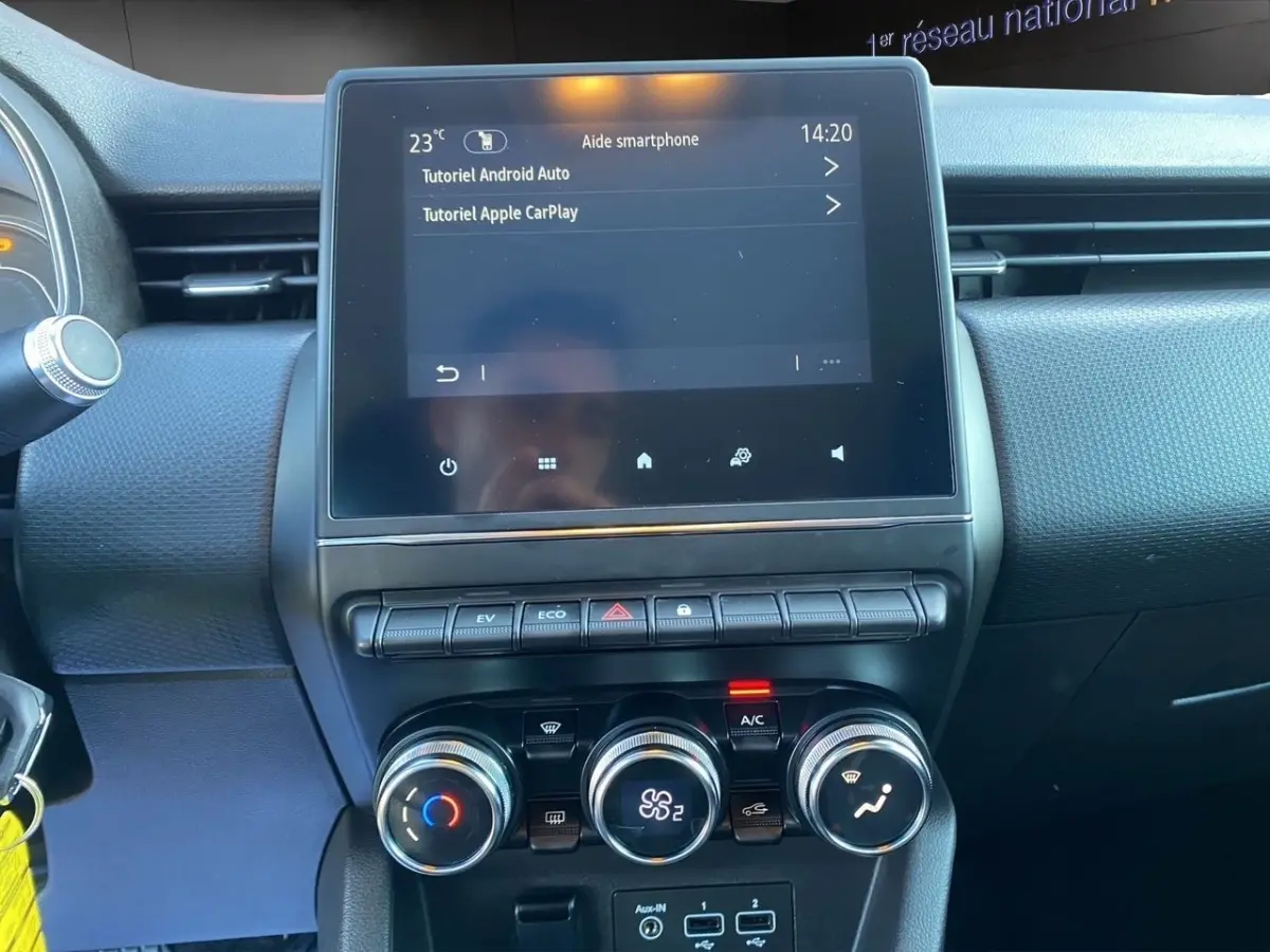 Vue rapprochée du tableau de bord de la Renault Clio Business E-TECH 140 2021, écran tactile central et commandes climatisation.