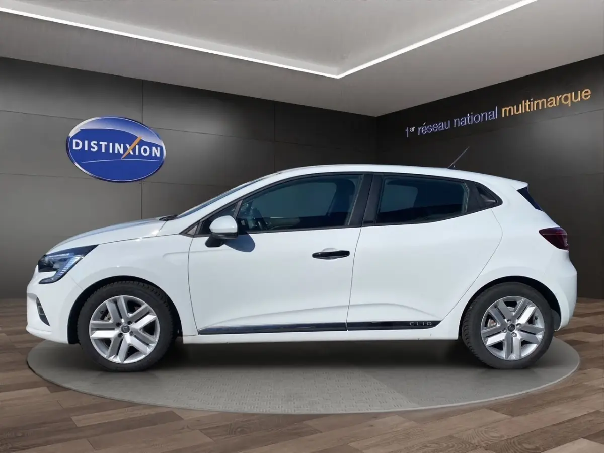 Profil droit d'une Renault Clio Business Réversible E-TECH 140 blanche, avec jantes alliage et logo Clio sur la porte.