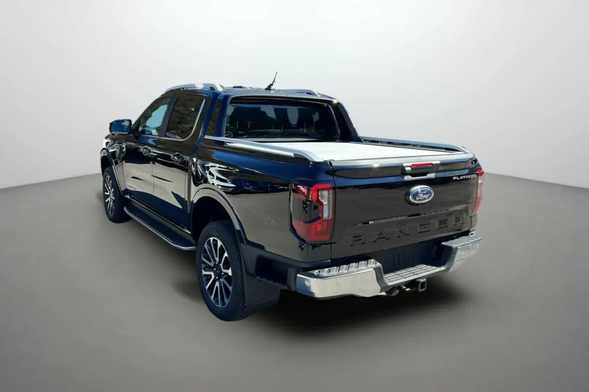Vue 3/4 arrière droite du Ford Ranger noir agate avec benne couverte et jantes alu 20 pouces distinctives.