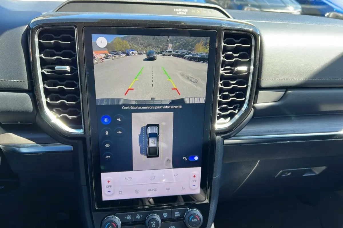 Vue rapprochée de la console centrale du Ford Ranger 2025 noir agate, écran tactile affichant la caméra de recul et les commandes climatisation.