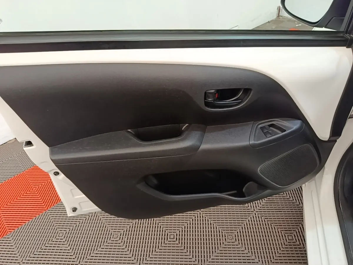 Intérieur côté gauche de porte avant blanche de Peugeot 108 2020, avec commande de vitre et poignée noire.