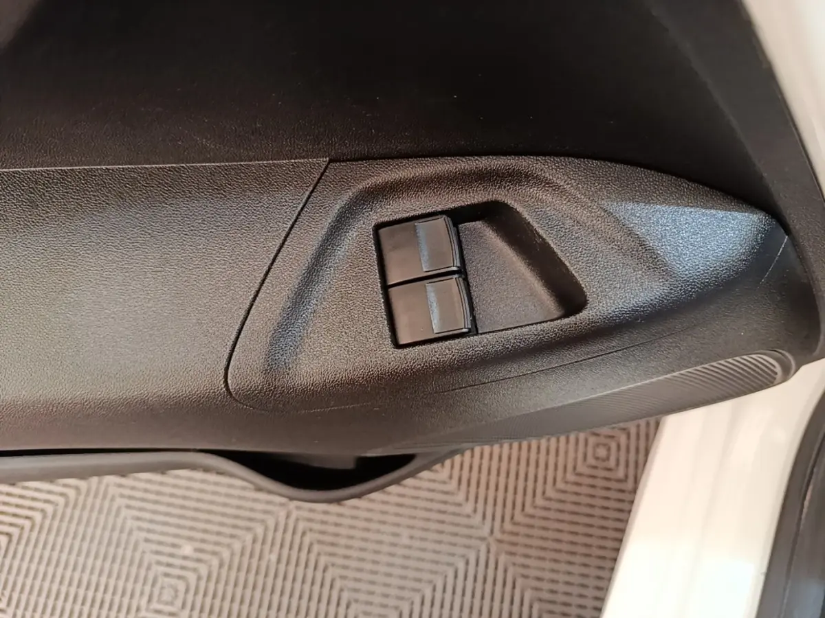 Gros plan sur les commandes des vitres électriques côté conducteur d’une Peugeot 108 blanche, version 2020.