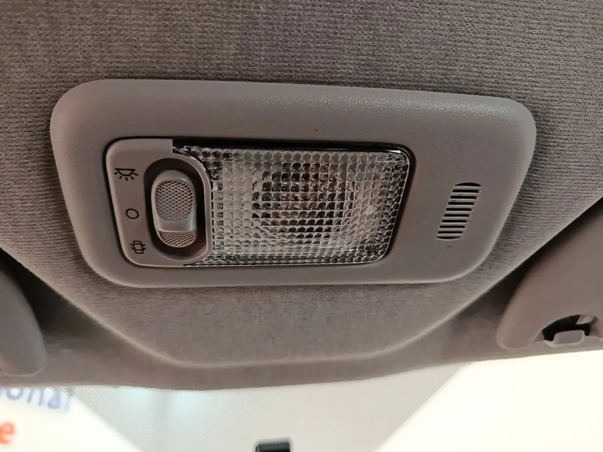 Plafonnier intérieur gris avec interrupteur de lumière, vue en gros plan du toit d'une Peugeot 108 blanche.