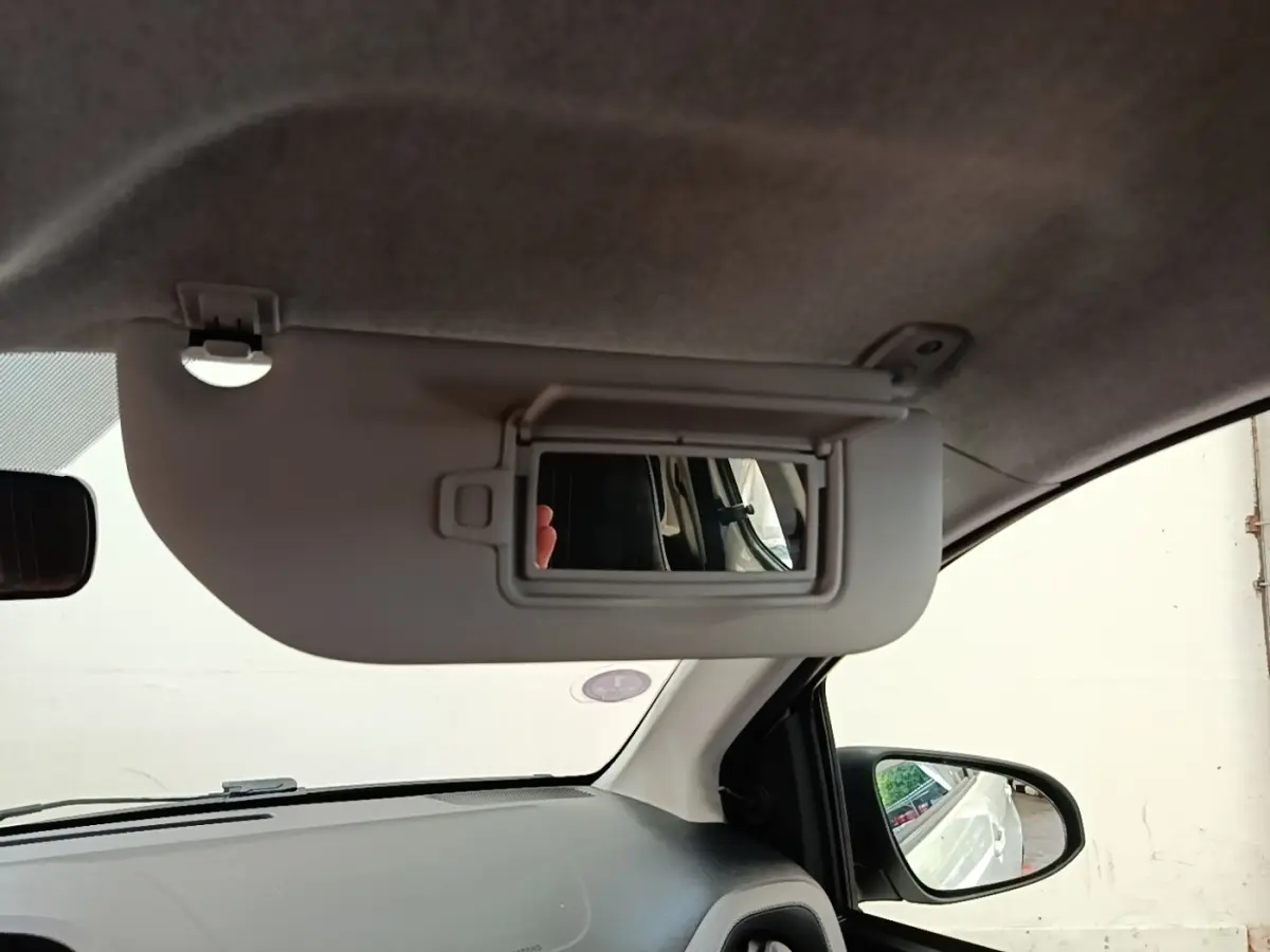 Intérieur du Peugeot 108 blanc 2020, vue côté conducteur sur pare-soleil avec miroir et rétroviseur extérieur.