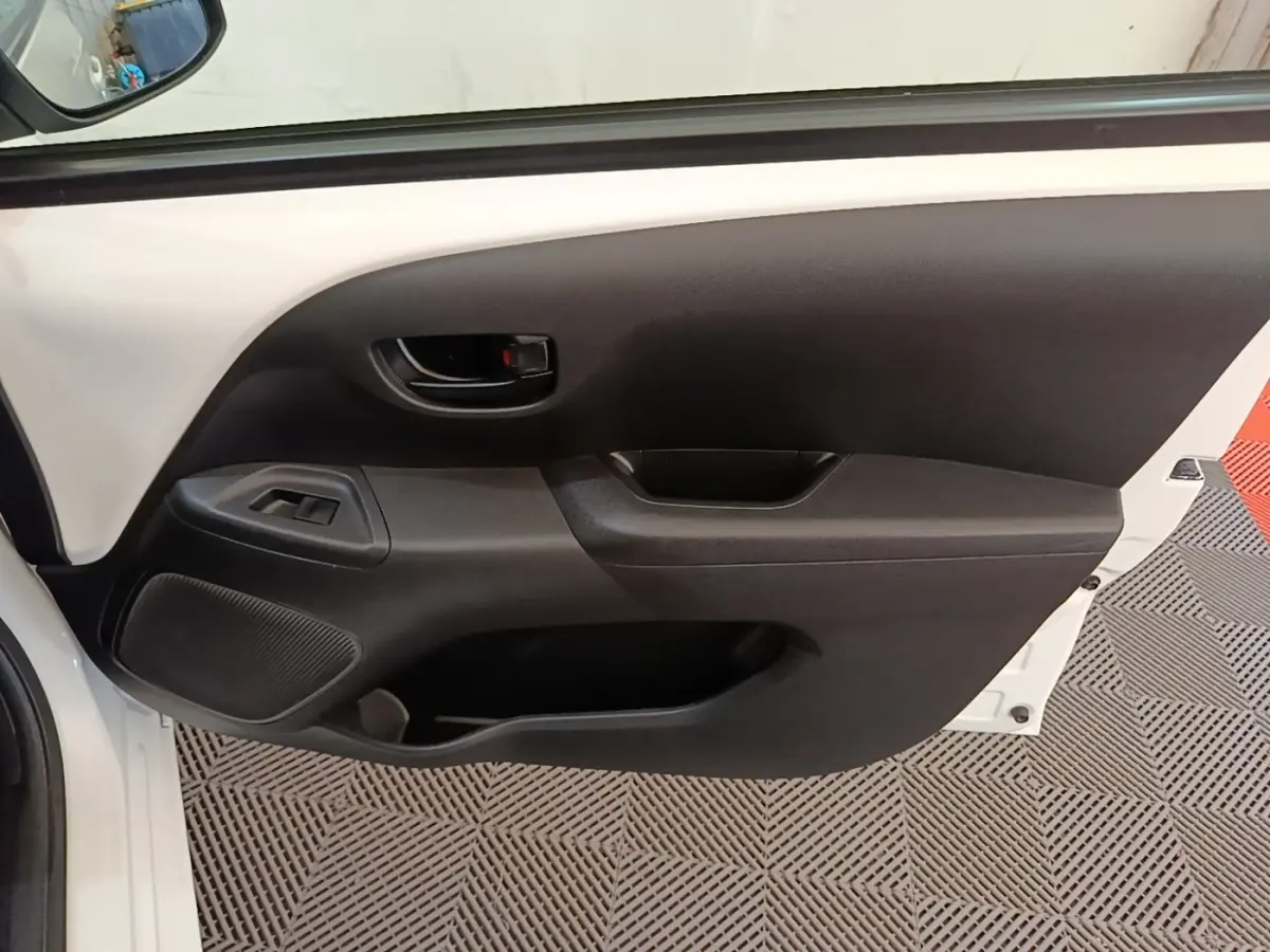Vue intérieure de la porte avant gauche blanche d’une Peugeot 108 VTI 72 S&S Active avec commandes de vitre et poignée noire.