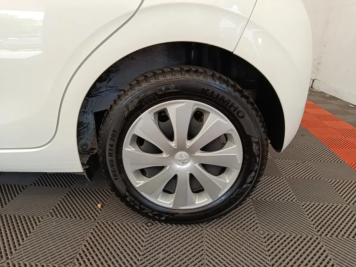 Gros plan sur la roue arrière droite blanche d'une Peugeot 108 VTI 72 S&S Active avec enjoliveur argenté.