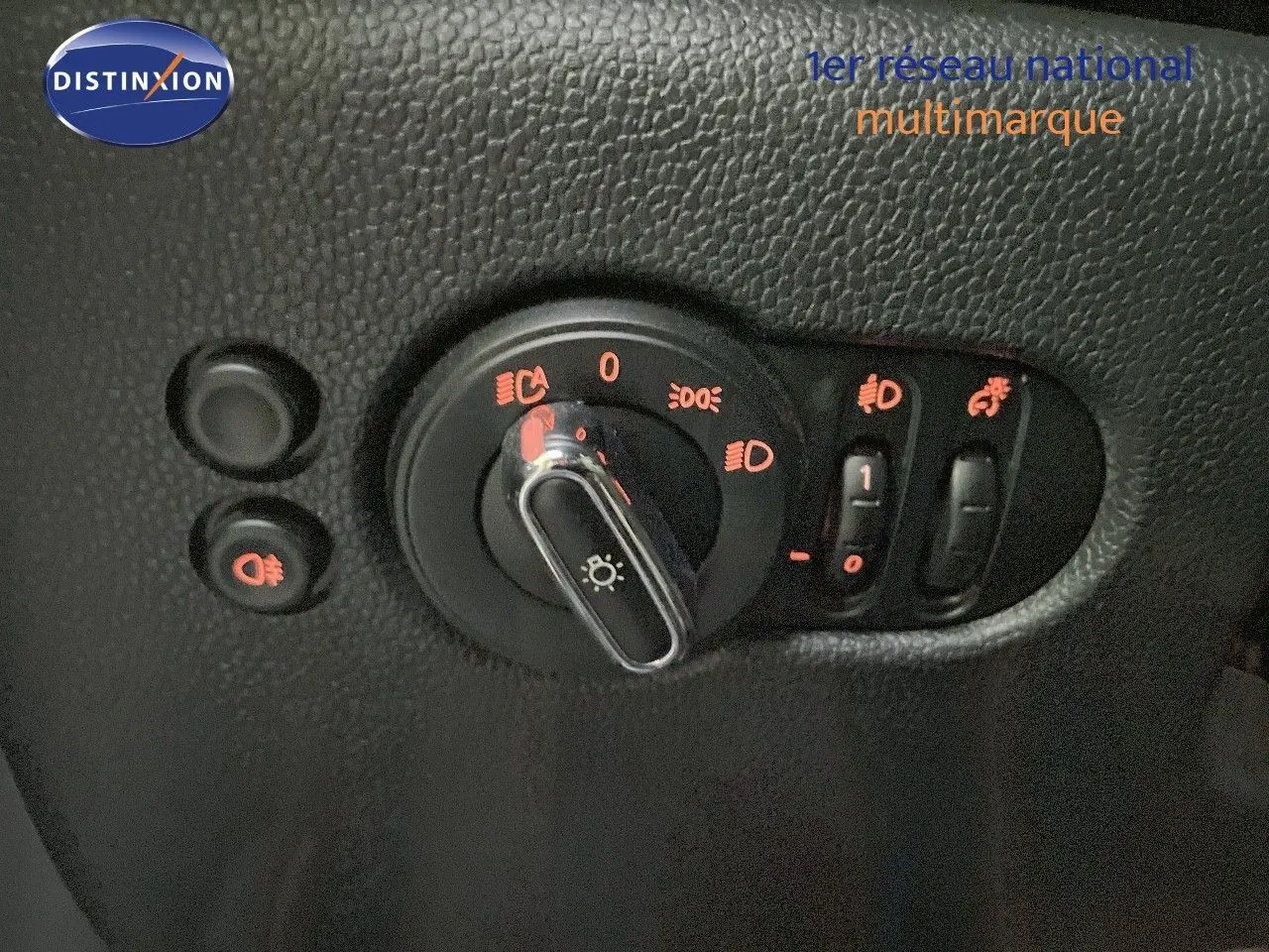 Gros plan sur les commandes d'éclairage intérieures de la MINI Cabriolet F57, avec boutons rétroéclairés rouges sur plastique noir texturé.
