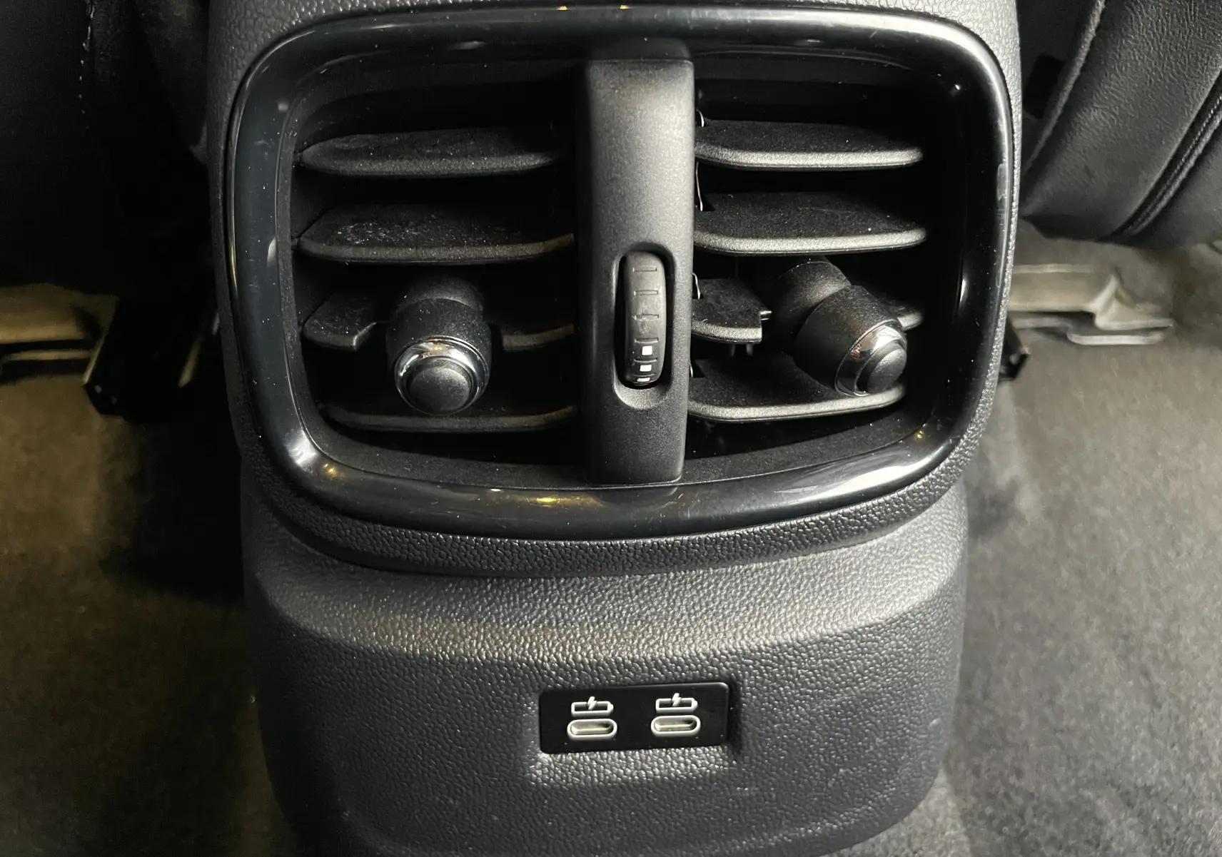 Gros plan sur la sortie d'air arrière noire et les deux ports USB du MINI Countryman hybride rechargeable.
