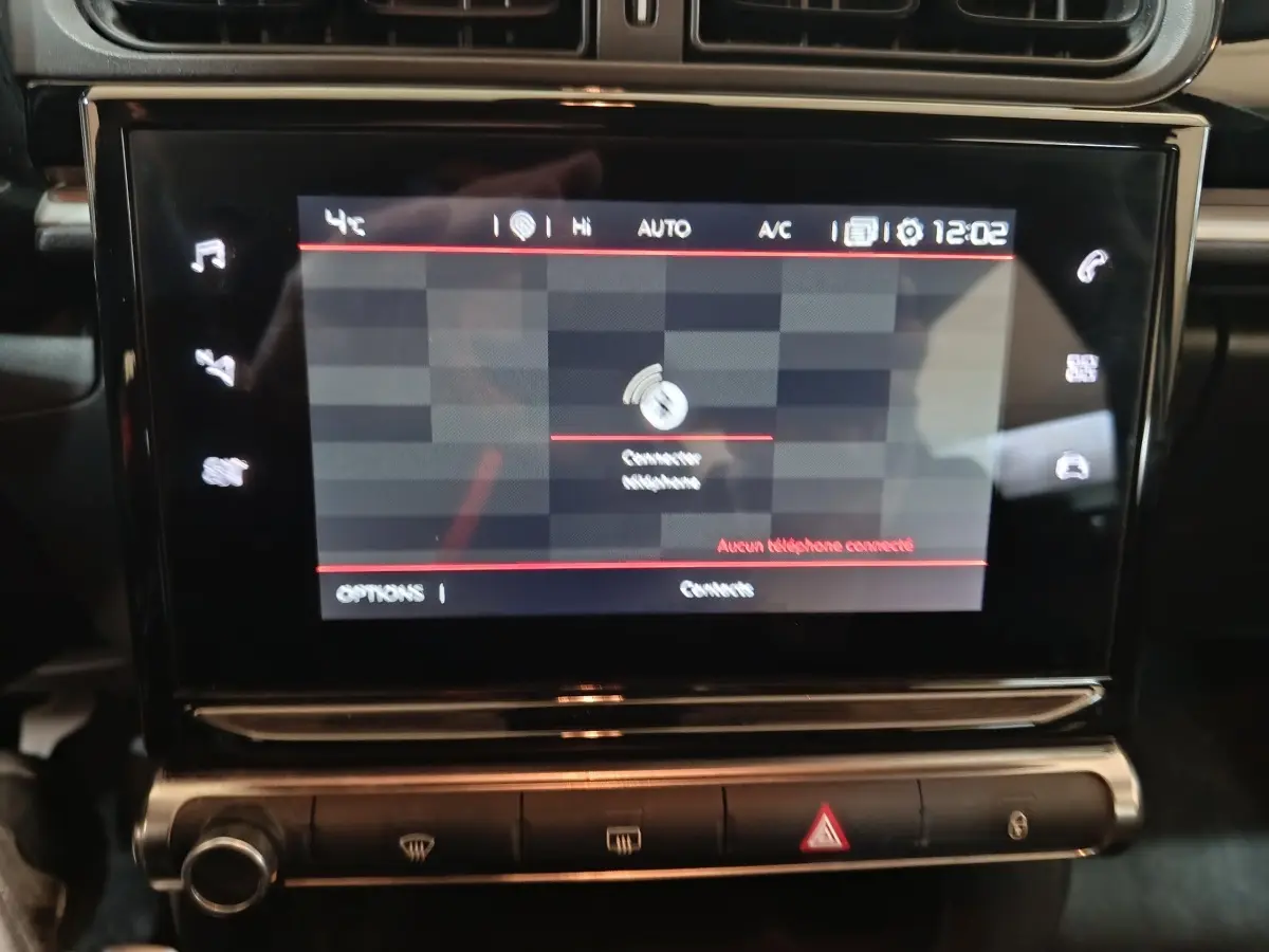 Écran tactile central allumé dans l'habitacle noir d'une Citroën C3 BlueHDi 100 BVM PLUS 2024.