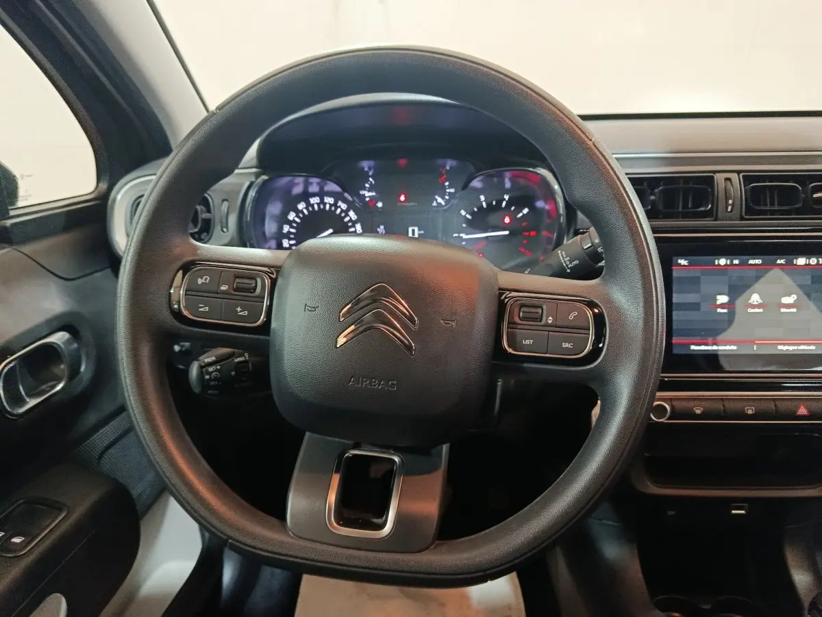 Vue intérieure centrée sur le volant noir multifonctions de la Citroën C3 2024 avec tableau de bord et écran tactile.
