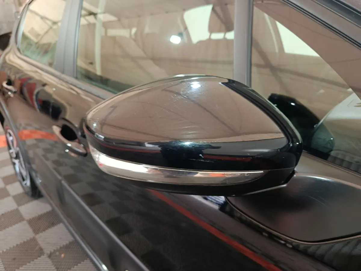 Gros plan sur le rétroviseur droit noir brillant de la Citroën C3 2024 avec clignotant intégré.