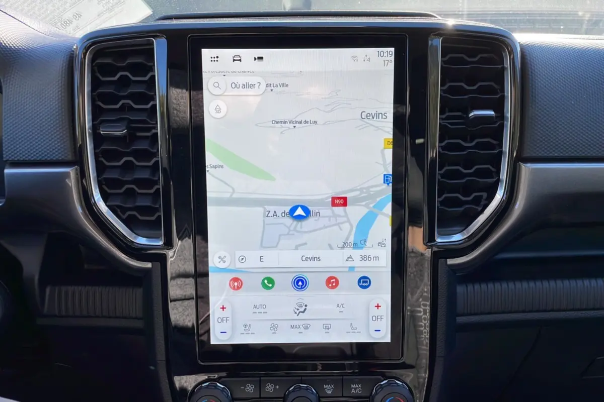 Écran tactile vertical du système de navigation du Ford Ranger 2025, avec commandes climatisation et aérateurs noirs.