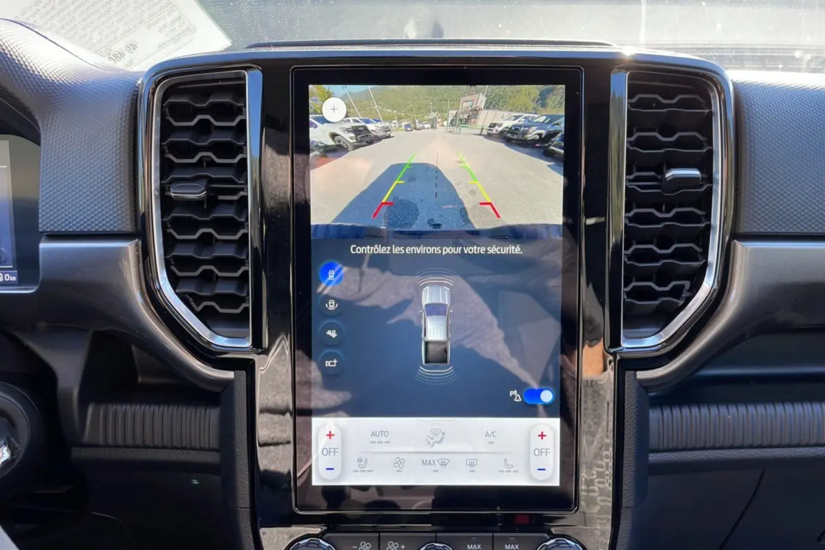 Vue rapprochée de l’écran tactile central du Ford Ranger gris Iconic 2025 avec caméra de recul et commandes climatisation.