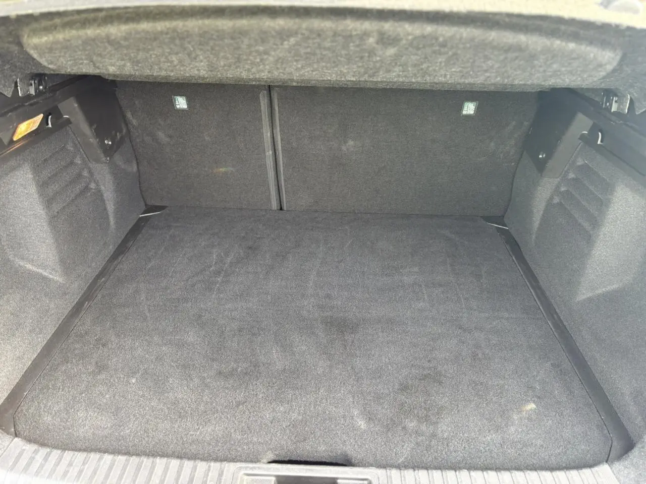 Coffre ouvert vu de face, intérieur entièrement noir avec plancher plat et revêtement tissu.